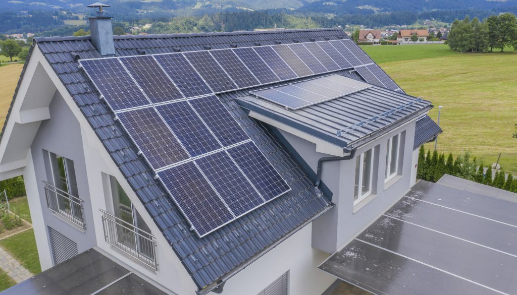 High angle shot of a private house situated in a valley with solar panels on the roof